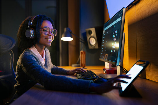 Young woman works on computer at night
