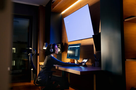 Woman uses computer at night in office
