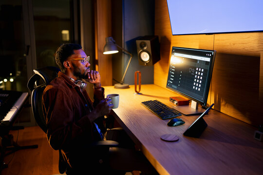 Man at desk with cup and PC

