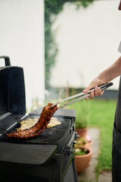 Man Grilling Ribs and Chicken Outdoors