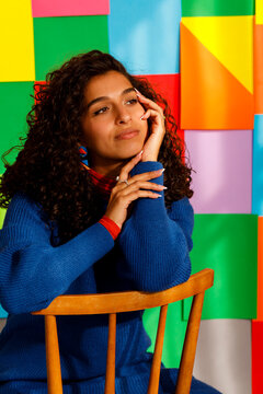 Portrait of a Woman Sitting on a Chair With Colorful Background