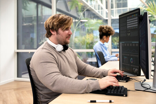 Male programmer working with data analysis in office