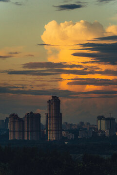 Clouds above city buildings at sunset in summer