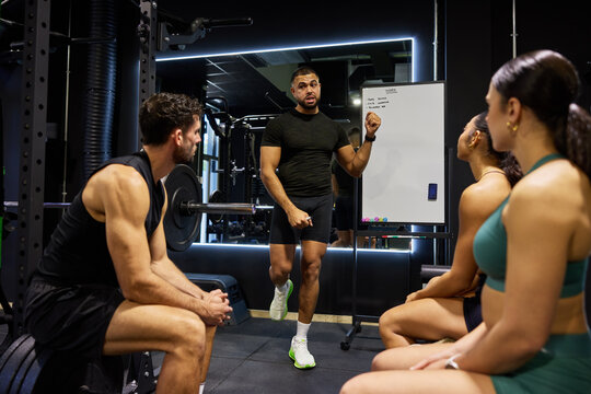 Trainer gives instructions to athletes in gym session