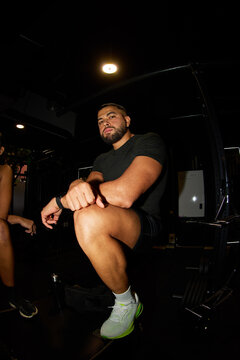 Man resting in gym during workout session at night time