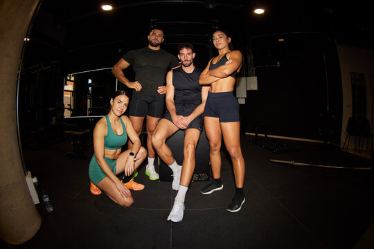 Group of friends posing after workout in gym setting