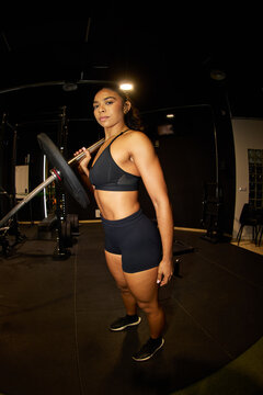 Woman lifts weight in gym during workout session