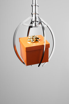 3D render of claw grabbing a single orange gift box