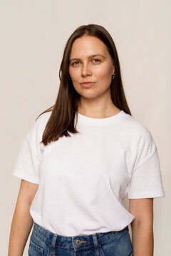 Woman Stands Facing the Camera Wearing a White Shirt in a Studio