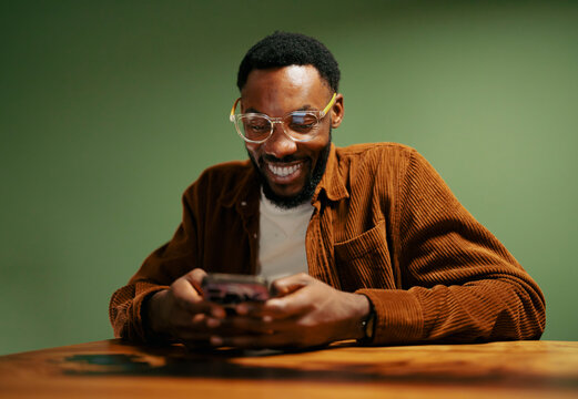 Man enjoys phone at a wooden table
