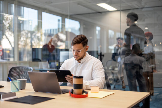 Professional man working with digital tablet in modern office