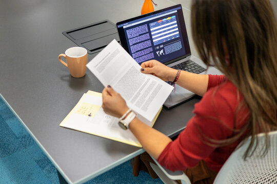 Woman working with documents and laptop in office