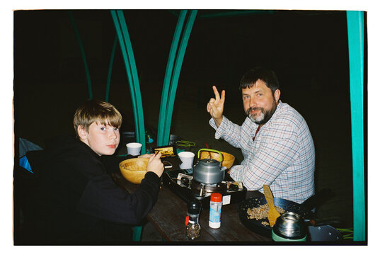 Father and Son Enjoying a Peaceful Dinner Under a Starlit Sky