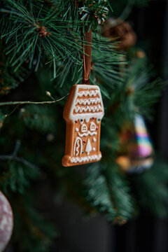 Gingerbread House Ornament Hanging on Christmas Tree Branch