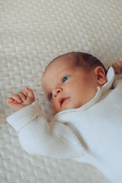 Baby on white bedsheet