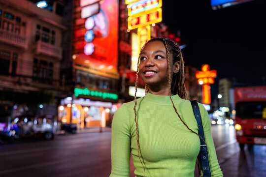 Smiling woman in city street at night.