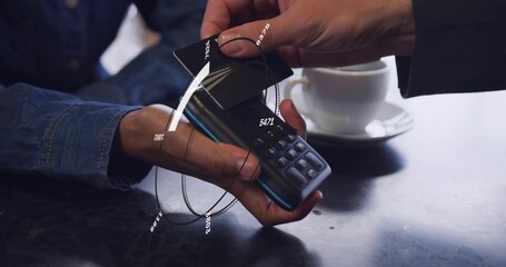 Tapping two hands' black card on reader at cafe table, denim sleeve, dark jacket, overlay, cup