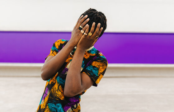 Face covered with hands portrait