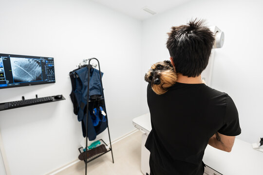 Owner cuddling dog during veterinary x ray exam