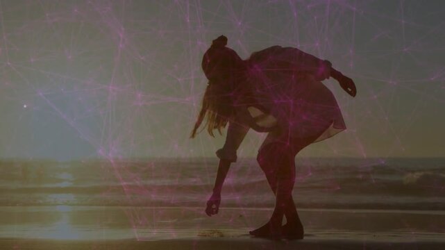 Woman walking wet shore at golden hour, spotting shell, bending and inspecting with travel overlay
