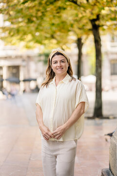 Pregnant woman smiling standing on city street