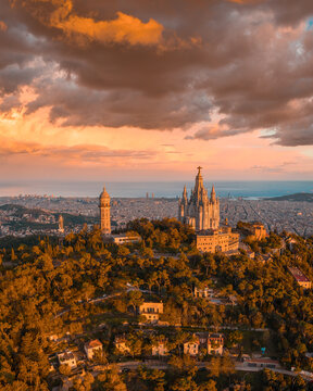 Sunset view from Tibidabo mountain as warm golden light spreads across the Barcelona skyline. The elevated viewpoint and glowing city create a dramatic Mediterranean cityscape at golden hour
