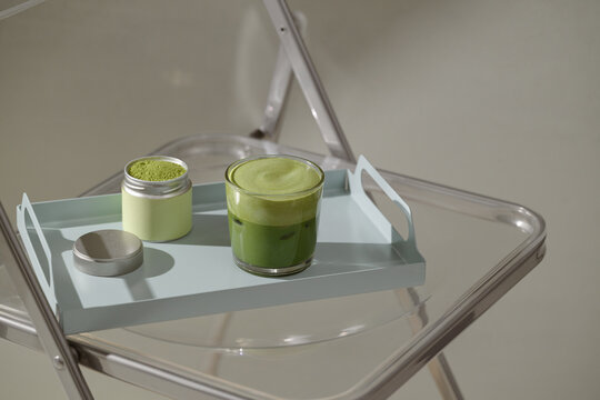 Refreshing matcha latte served on a tray with matcha powder