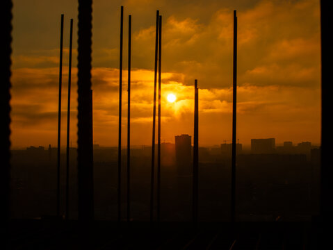 Reinforcement bars silhouetted at sunset on construction site