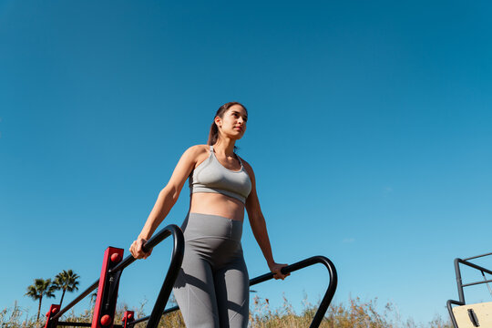 Pregnant woman exercising doing one leg squats outdoors 