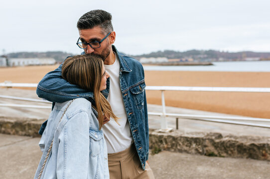 Couple embracing and kissing by the coast