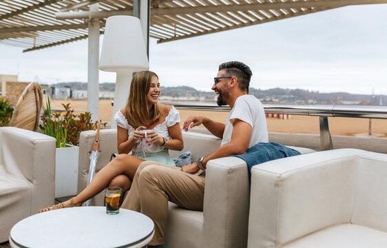 Friends laughing over drinks outdoors