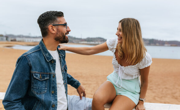 Playful couple smiling beachfront