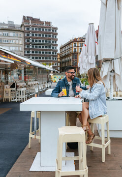 Couple enjoying drinks at an outdoor city bar