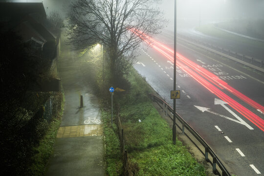 A road and cycle path, on a foggy winters night