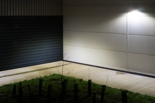 An industrial building with new tree saplings on a winters night