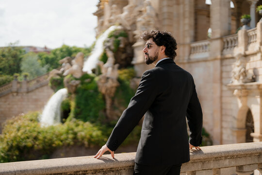 An elegant man in a black suit is enjoying his free time in the city