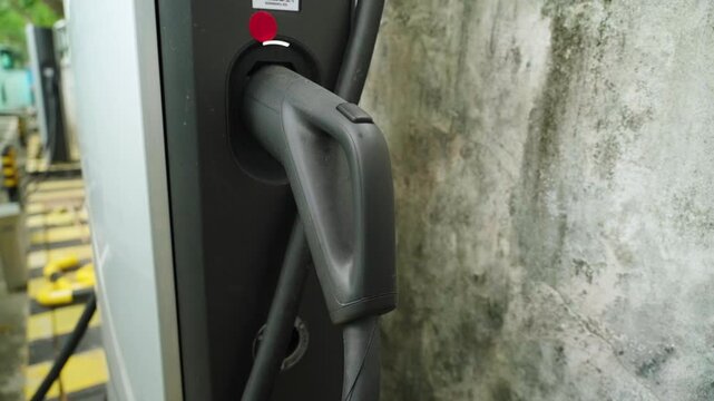 High power fast charging cable connected to BYD charging station in Shenzhen, China. Close-up of charging infrastructure supporting clean public transport and sustainable urban mobility.