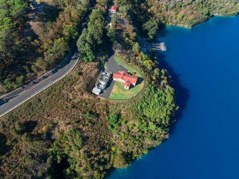 Pumping station on the sloping edges of a blue crater lake