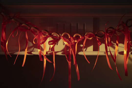 Red ribbons hang on a wall in soft light