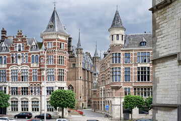 Beautiful historic brick buildings with ornate towers and gables in Antwerp, Belgium. Classic Flemish architecture under a cloudy sky