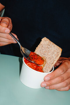 a man eating tomato soup with bread at a table
