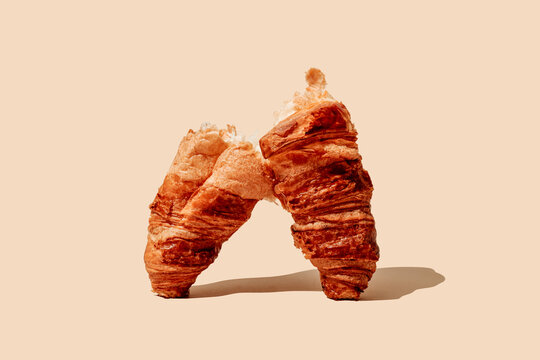 a split croissant forming an arch on a beige surface
