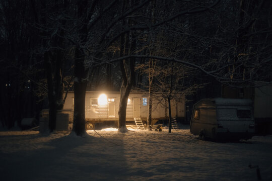 cozy trailer glowing in snowy forest