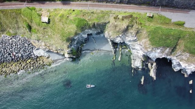 Aerial shot of a rocky cove and turquoise sea water.