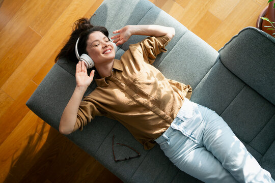 Enjoying music on a gray sofa
