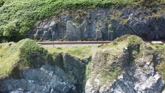 Detailed aerial of a coastal railway line and rocks.
