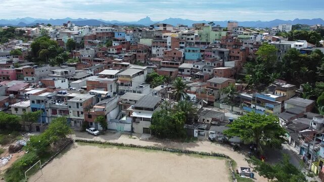 Aerial perspective of an urban neighborhood surrounding a dirt pitch.