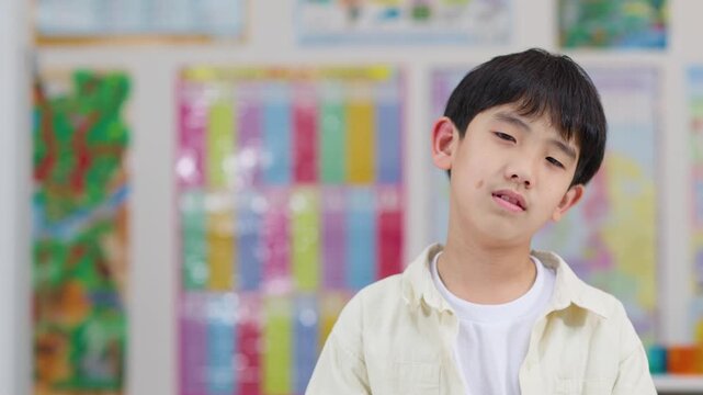 Bored Asian Schoolboy Reacting Unhappily in Classroom Closeup