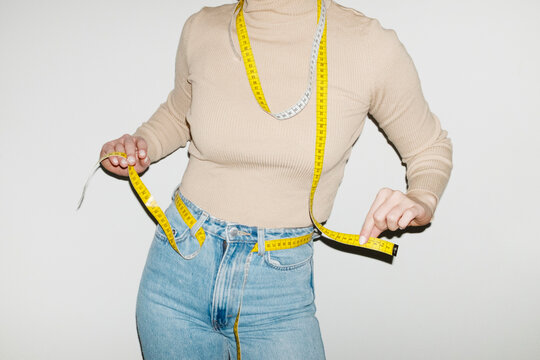 Person having yellow measurement tapes around their body with flash