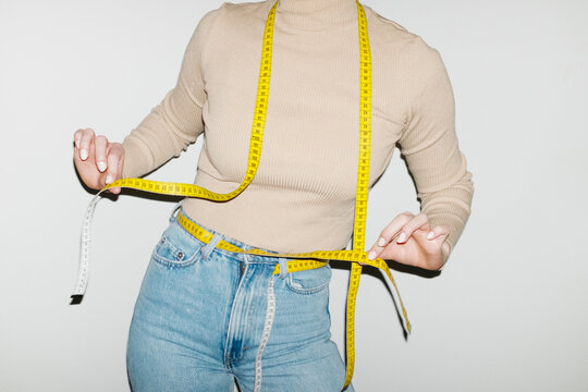 Person having yellow measurement tapes around their body with flash